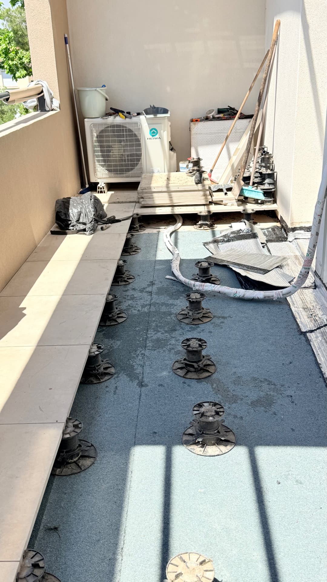 Pose de la membrane d'étanchéité autoprotégée sur le balcon avant repose des dalles sur plots