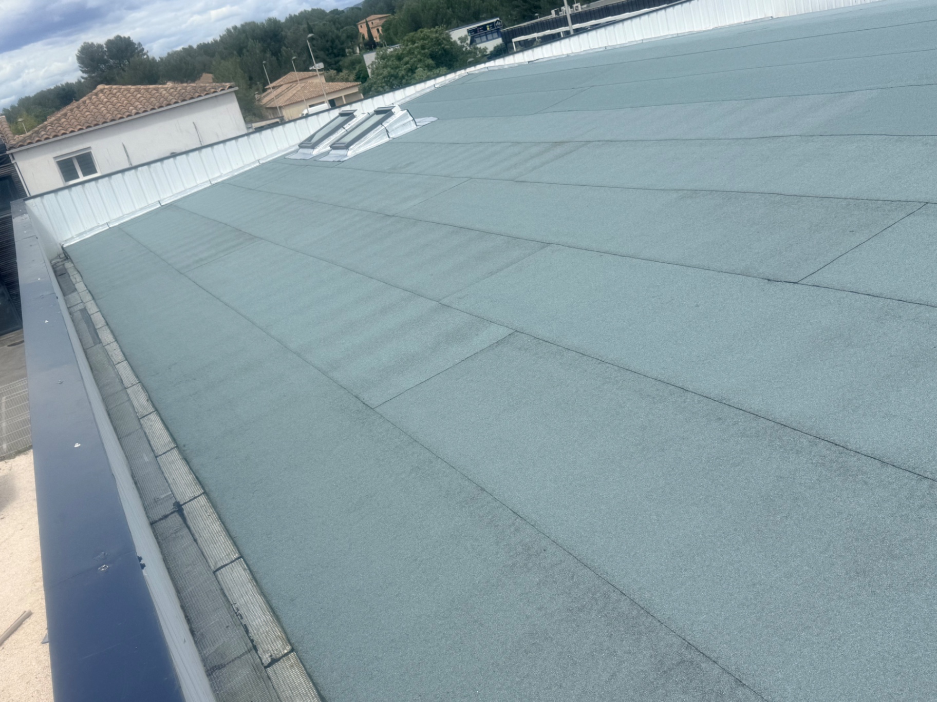 Vue d'ensemble de la toiture bac acier terminée avec membrane autoprotégée à paillettes minérales