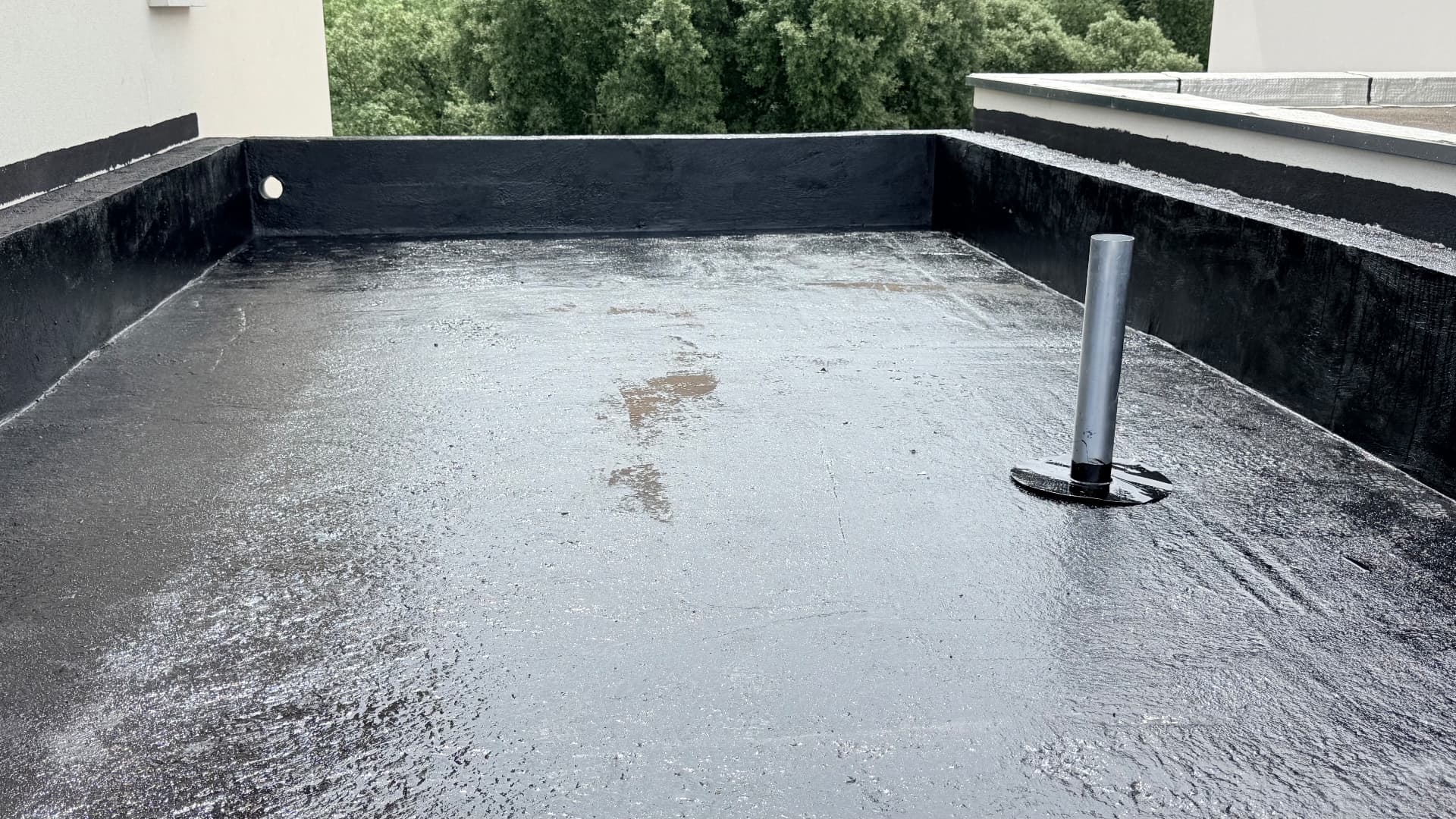 Toiture-terrasse et relevés d'acrotère traités en enduit d'imprégnation avant la pose de l'étanchéité