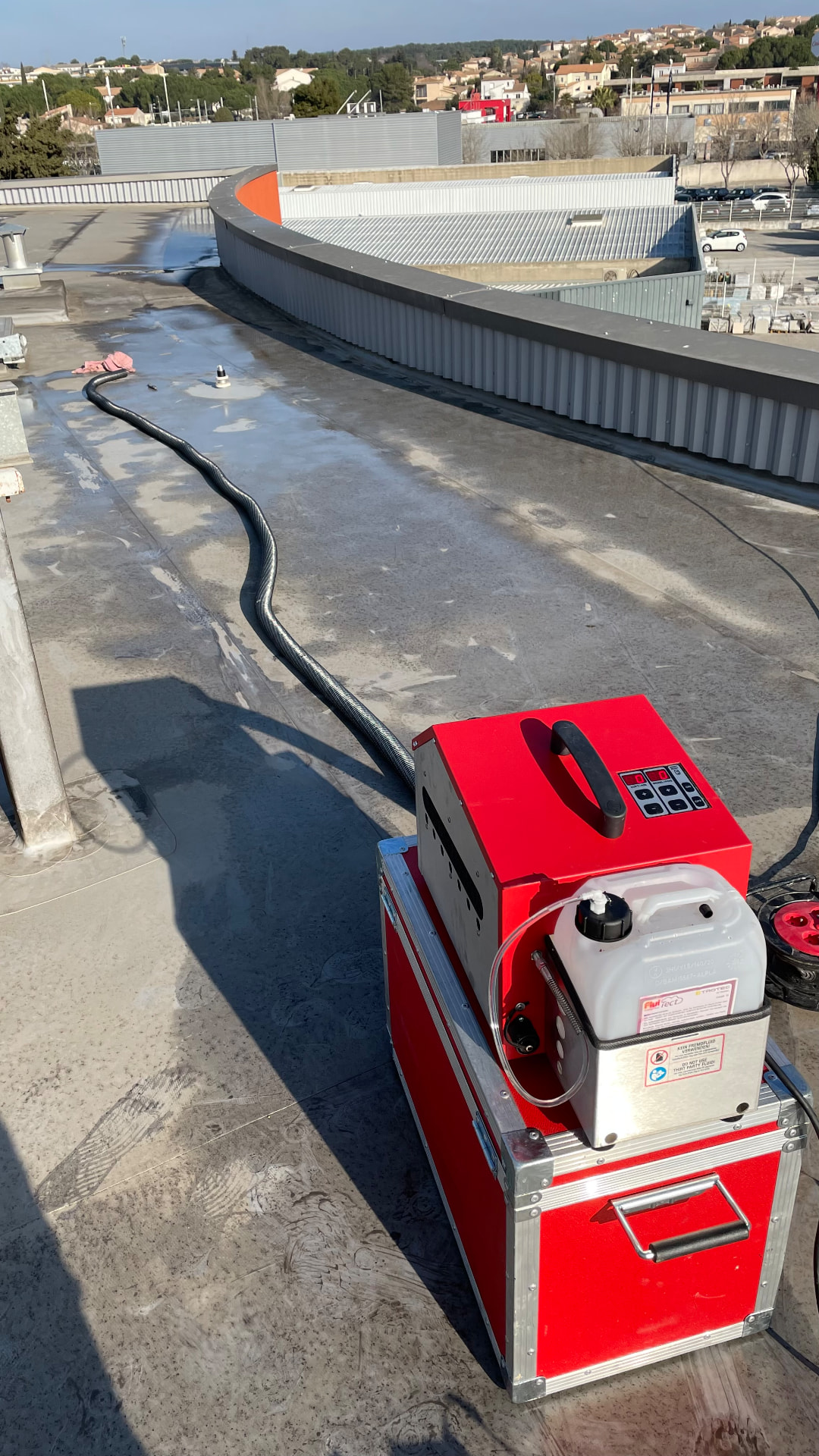 Vue d'ensemble d'un test fumigène sur une grande toiture-terrasse de bâtiment