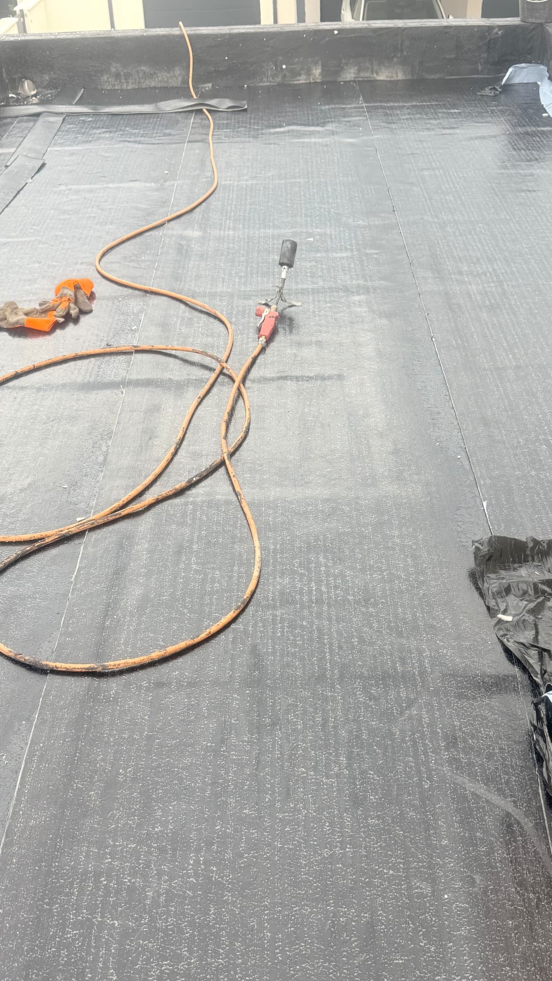 Soudage au chalumeau des lés bitumineux sur la toiture-terrasse en cours de chantier