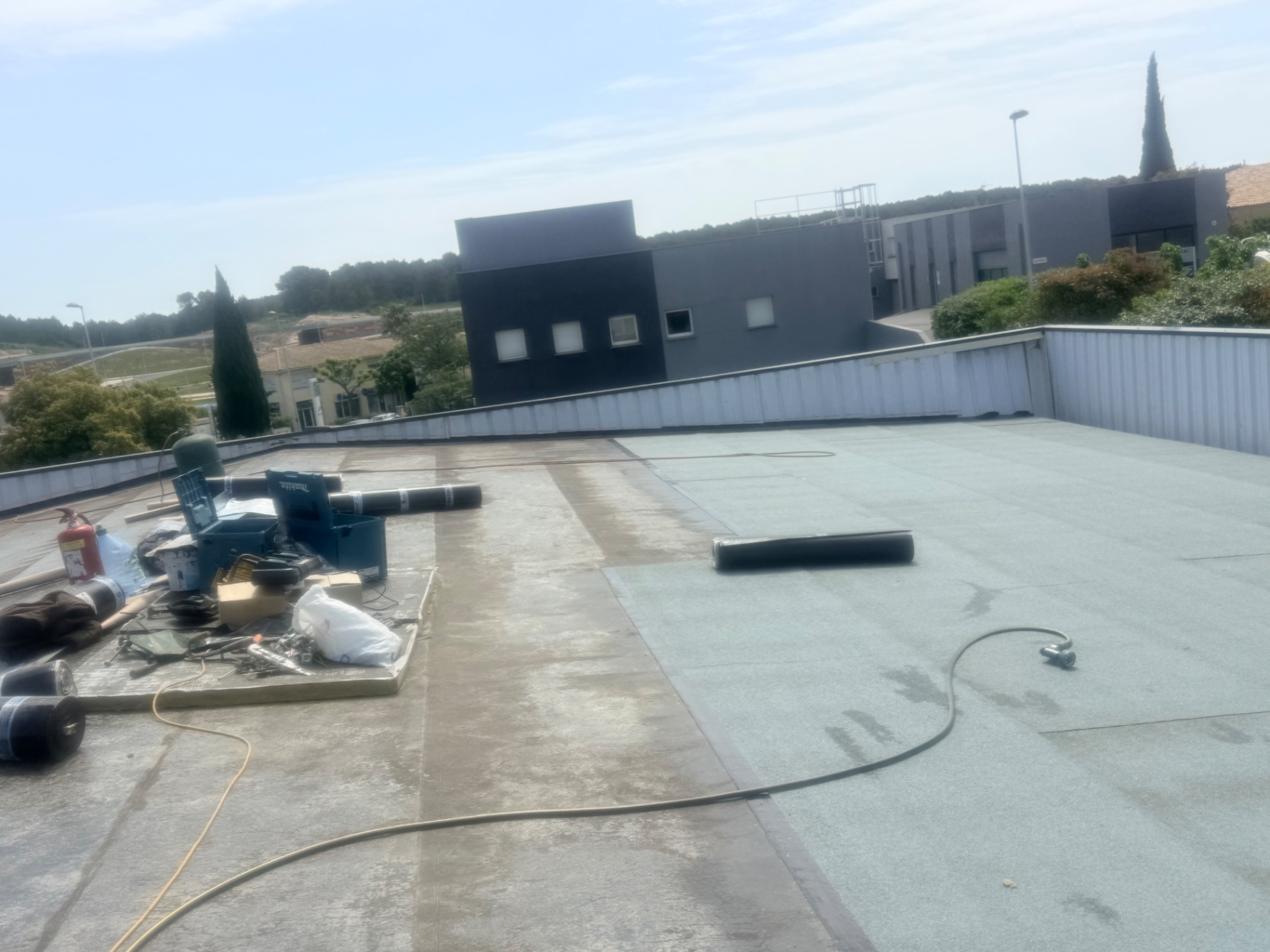 Déroulage et soudage de la membrane autoprotégée sur l'isolant de la toiture bac acier